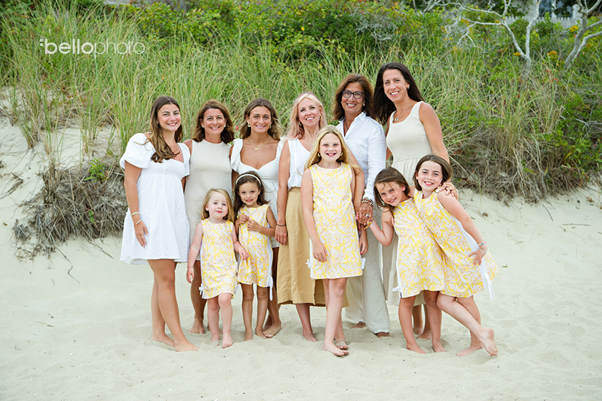 family of women and girls in yellow and white dresses at the beach