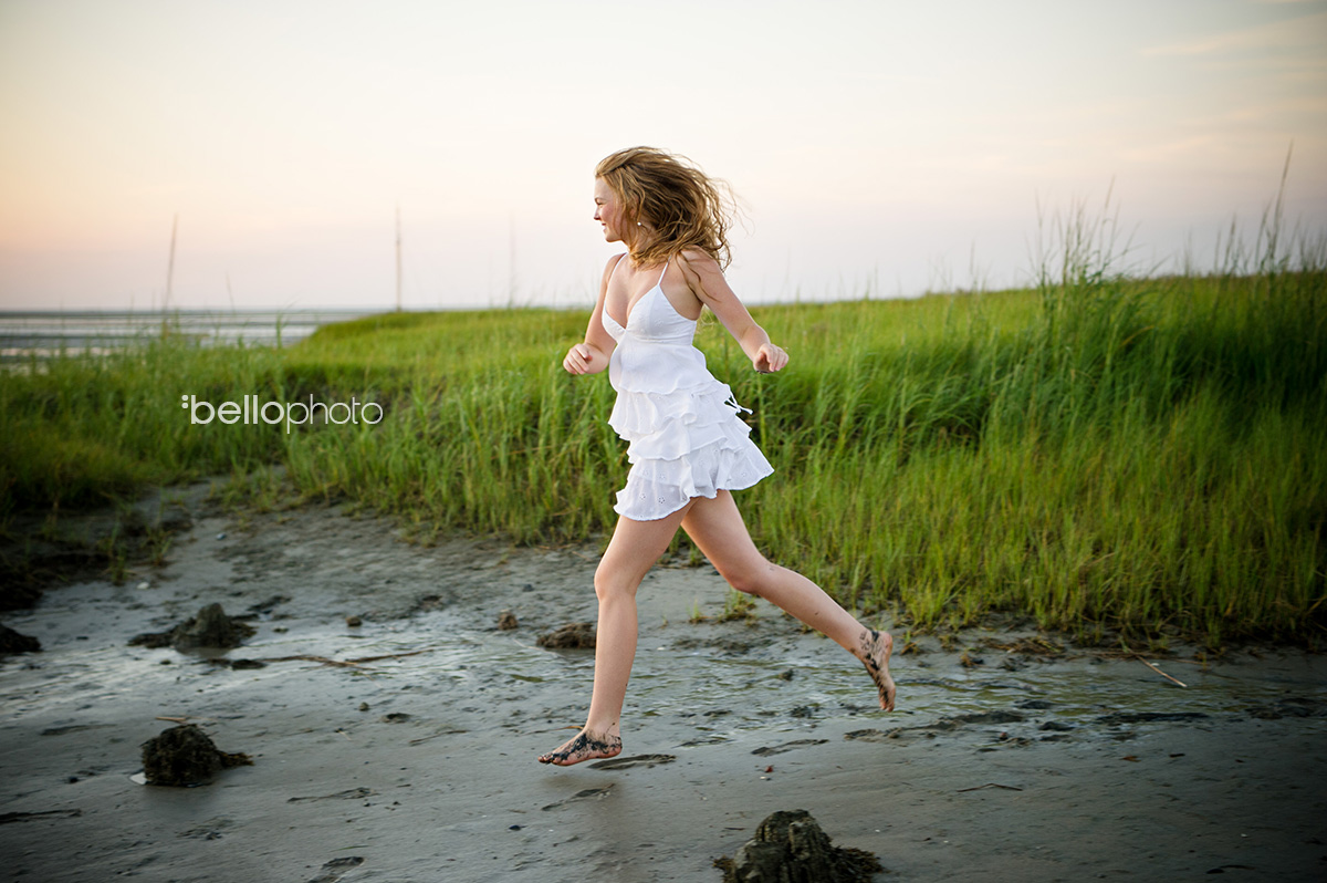 beautiful girl running along beach at sunset