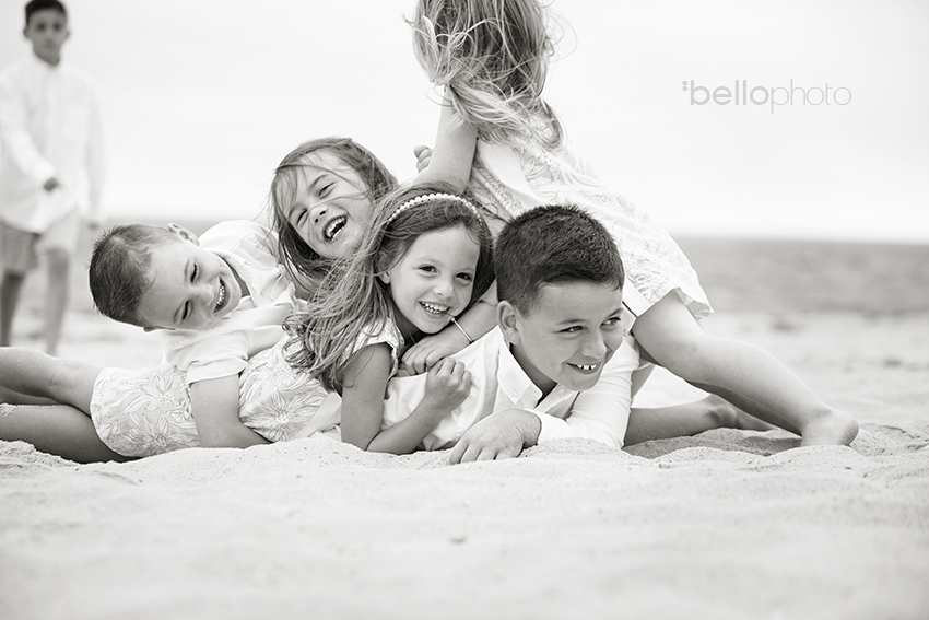 kids pig piling at the beach, black & white photo